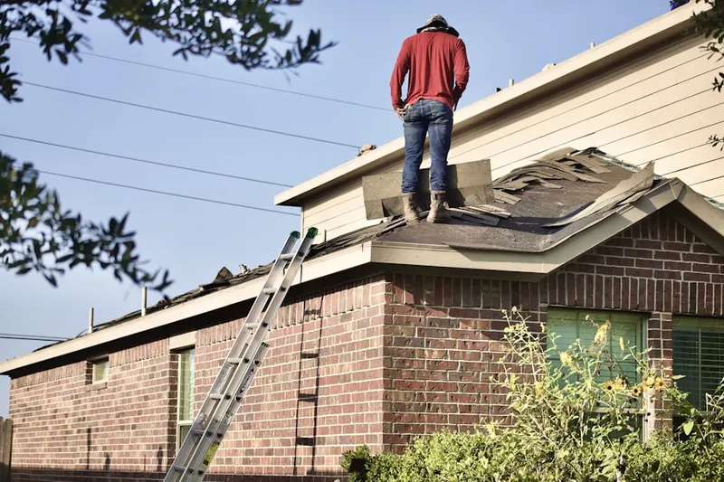 Professional roofer working on a residential roof in Batter Brook Farms